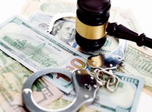 A judge's gavel and handcuffs resting on American dollars in Columbus, Ohio, symbolize money laundering